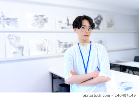 藝術系學生在工作室裡雙手交叉抱在胸前。 藝術系學生在工作室裡雙手交叉抱在胸前。 140494149