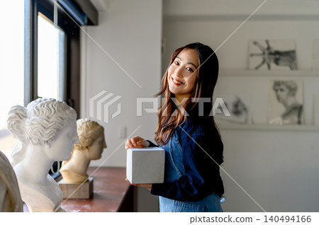 A student holding a cube at an art preparatory school A student holding a cube at an art preparatory school 140494166