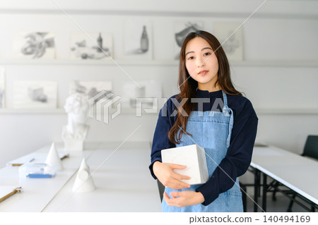 一位來自藝術預科學校的女生手裡拿著一個立方體。 140494169