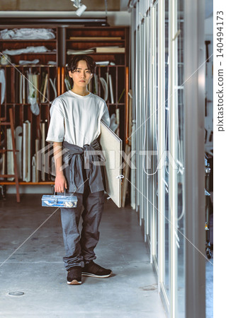 A male student with a canvas in his studio A male student with a canvas in his studio 140494173