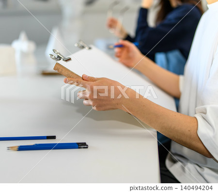 A student adjusting a drawing board at an art preparatory school. A student adjusting a drawing board at an art preparatory school. 140494204