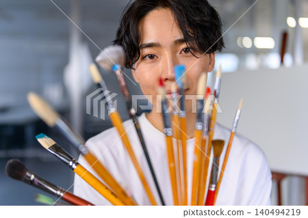 一位微笑的藝術系學生手持畫筆 140494219
