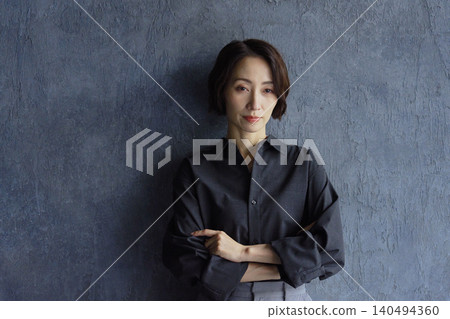Businesswoman standing against a black background Businesswoman standing against a black background 140494360