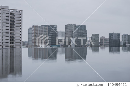 陰天;高輪水池中倒映著高樓大廈;城市景觀。 陰天;高輪水池中倒映著高樓大廈;城市景觀。 140494451