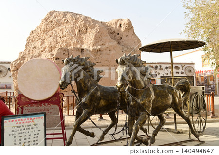 The ancient metal horses and carriage statues in the ancient city of Kuche on the Silk Road and the enchanting city of Aksu. Kuche, a colorful ancient kingdom. The ancient metal horses and carriage statues in the ancient city of Kuche on the Silk Road and the enchanting city of Aksu. Kuche, a colorful ancient kingdom. 140494647
