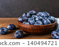 Fresh plums in a clay bowl. 140494721