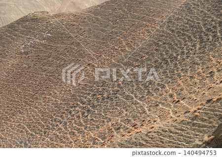 Texture or background of the mountain surface, shaped by the wind, reveals beautiful patterns, like streams of water bathed in sunlight. 140494753