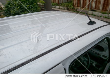 The rain is wetting the roof of the car. The rain is wetting the roof of the car. 140495025