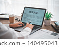 People are reviewing job applications before filling out their resume on the job application form in order to apply for a job at a company. 140495043