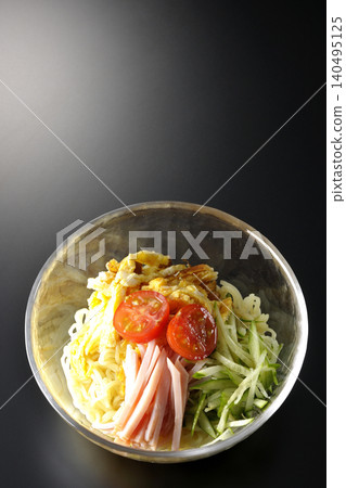 A single serving of chilled ramen in a clear glass bowl, photographed against a black background. A single serving of chilled ramen in a clear glass bowl, photographed against a black background. 140495125
