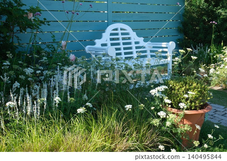 A white bench and plants in a stylish garden A white bench and plants in a stylish garden 140495844