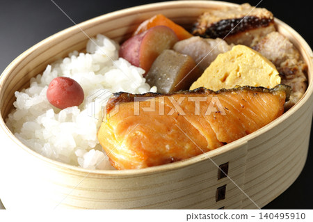 Grilled fish bento photographed against a black background Grilled fish bento photographed against a black background 140495910