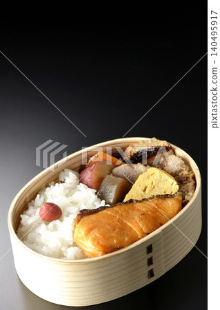 Grilled fish bento photographed against a black background Grilled fish bento photographed against a black background 140495917