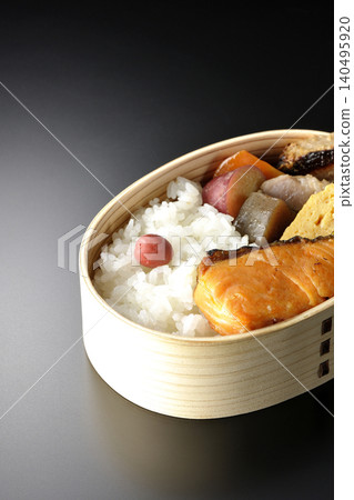 Grilled fish bento photographed against a black background Grilled fish bento photographed against a black background 140495920