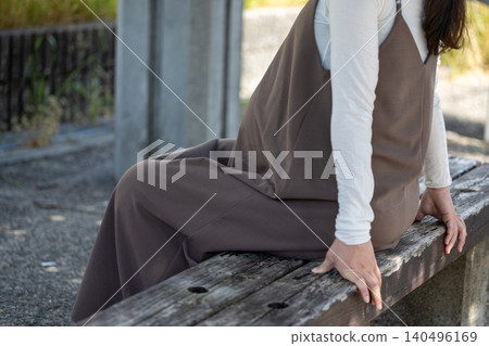 A pregnant woman in her final month of pregnancy resting on a bench in the shade. A pregnant woman in her final month of pregnancy resting on a bench in the shade. 140496169