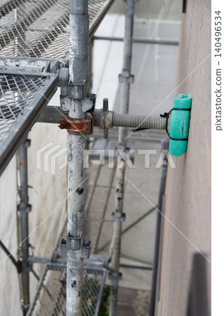 Close-up of scaffolding and protective coverings used during exterior wall painting. Close-up of scaffolding and protective coverings used during exterior wall painting. 140496534
