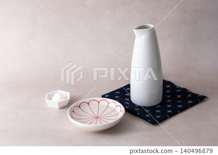An image of a Shinto ritual or purification using a sake bottle and salt dish. 140496879