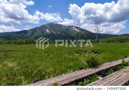 The Oze wetlands, boardwalks, and distant mountains. The Oze wetlands, boardwalks, and distant mountains. 140497886