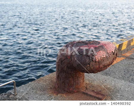Mooring posts standing on the quay; seascape; copy space; background; wabi-sabi; art of rust. Mooring posts standing on the quay; seascape; copy space; background; wabi-sabi; art of rust. 140498392