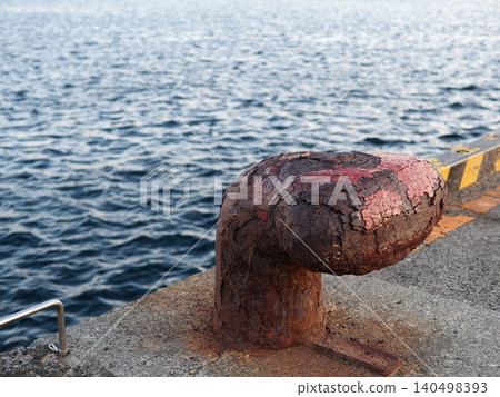 Mooring posts standing on the quay; seascape; copy space; background; wabi-sabi; art of rust. Mooring posts standing on the quay; seascape; copy space; background; wabi-sabi; art of rust. 140498393
