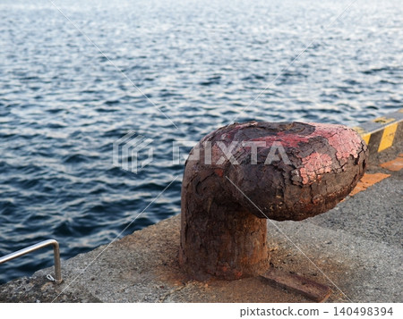 Mooring posts standing on the quay; seascape; copy space; background; wabi-sabi; art of rust. 140498394