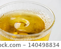 Cold, amber-colored tea poured into a glass filled with ice. 140498834