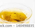 Cold, amber-colored tea poured into a glass filled with ice. 140498835