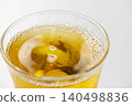 Cold, amber-colored tea poured into a glass filled with ice. 140498836