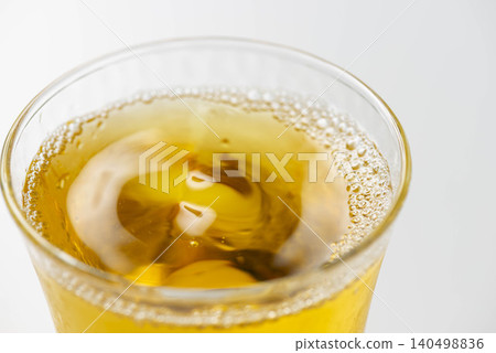 冰涼的琥珀色茶水倒入裝滿冰塊的玻璃杯中。 冰涼的琥珀色茶水倒入裝滿冰塊的玻璃杯中。 140498836