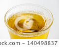 Cold, amber-colored tea poured into a glass filled with ice. 140498837