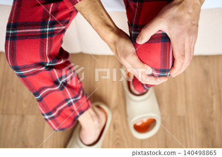 Person suffering from knee pain in the morning Person suffering from knee pain in the morning 140498865