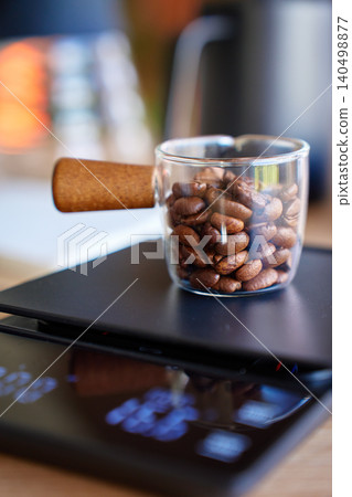 Weighing coffee beans in glass cup on digital scale 140498877