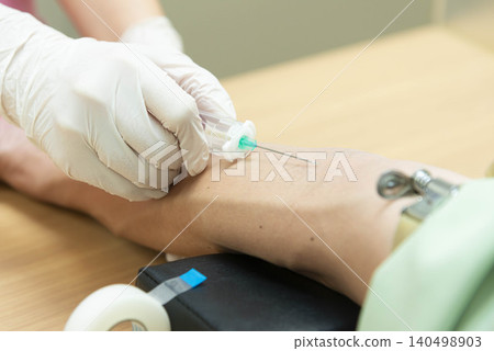 The hands of a healthcare worker administering a vaccination to a patient's arm in a medical setting. The hands of a healthcare worker administering a vaccination to a patient's arm in a medical setting. 140498903