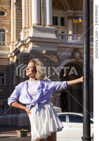 Woman poses confidently near a historic building under sunlight Woman poses confidently near a historic building under sunlight 140499642