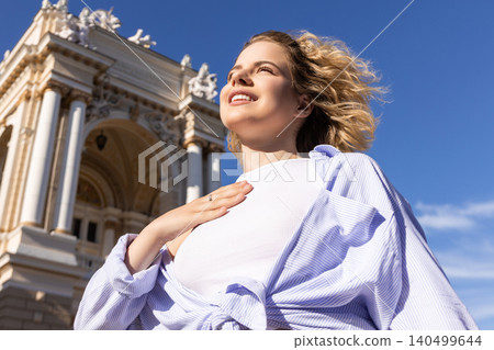 Woman smiles at the grand architecture while embracing freedom Woman smiles at the grand architecture while embracing freedom 140499644