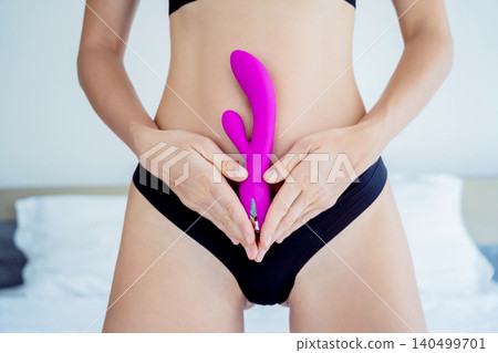 Young sexy woman holding in her hands a sex toy for adults Young sexy woman holding in her hands a sex toy for adults 140499701