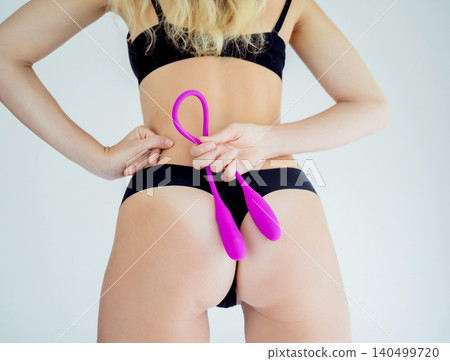 Young sexy woman holding in her hands a sex toy for adults Young sexy woman holding in her hands a sex toy for adults 140499720