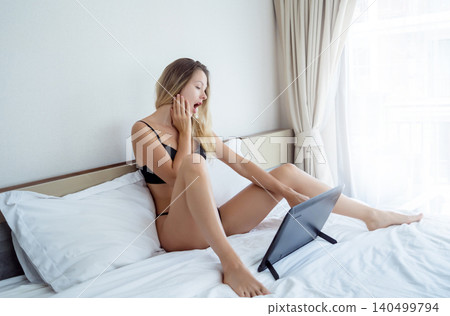 Young sexy woman posing in front of camera and working as webcam model Young sexy woman posing in front of camera and working as webcam model 140499794