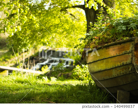 View of wooden rowing boat in lush green tree with waterfall background View of wooden rowing boat in lush green tree with waterfall background 140499837