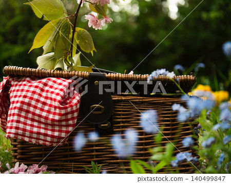 Vintage picnic basket through view of summer flowers 140499847