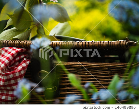 Vintage picnic basket through view of summer flowers Vintage picnic basket through view of summer flowers 140499896