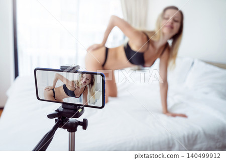 Young sexy woman posing in front of camera and working as webcam model Young sexy woman posing in front of camera and working as webcam model 140499912