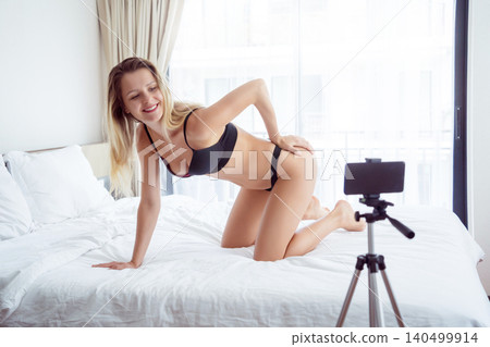 Young sexy woman posing in front of camera and working as webcam model Young sexy woman posing in front of camera and working as webcam model 140499914