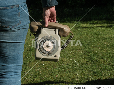 Woman holding vintage phone outside Woman holding vintage phone outside 140499978