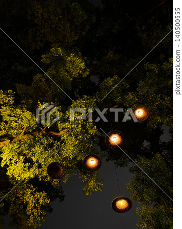 Hanging Traditional Bamboo Straw Hat Lanterns On Tree At Night Hanging Traditional Bamboo Straw Hat Lanterns On Tree At Night 140500555