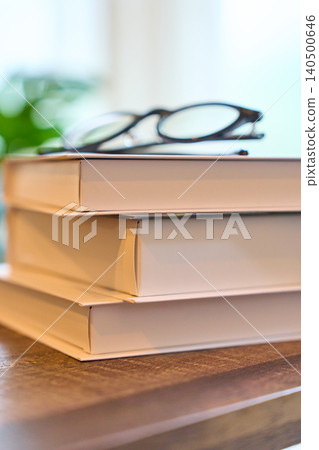 桌上放著一本書和一副眼鏡。 桌上放著一本書和一副眼鏡。 140500646