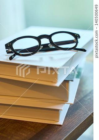 A book and glasses on the desk A book and glasses on the desk 140500649