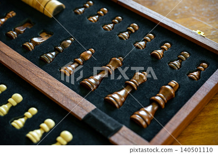 Chess pieces in wooden box on board game table 140501110