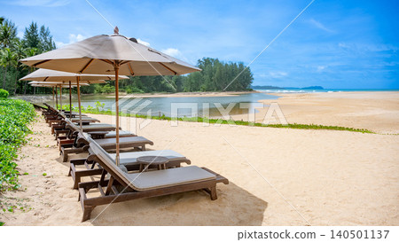 Beach chairs or loungers under the umbrellas on tropical beach 140501137