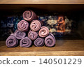 Group of rolled towels on wooden shelf 140501229